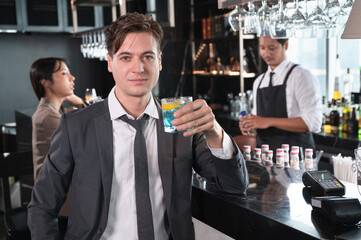 Handsome caucasian businessman drink cocktail at bar in hotel restaurant	