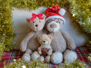 Christmas teddy bear family (two parents and one child) portrait with gold tinsel