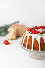 Dessert stand with traditional Christmas cake on light background