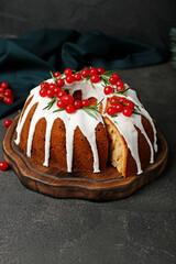 Wooden board with tasty Christmas cake on dark background, closeup