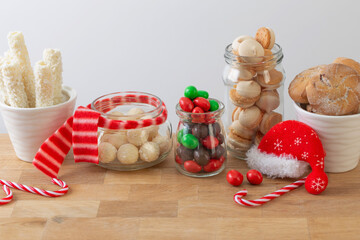 christmas candies and cookies  in jars on wooden shelf on white background