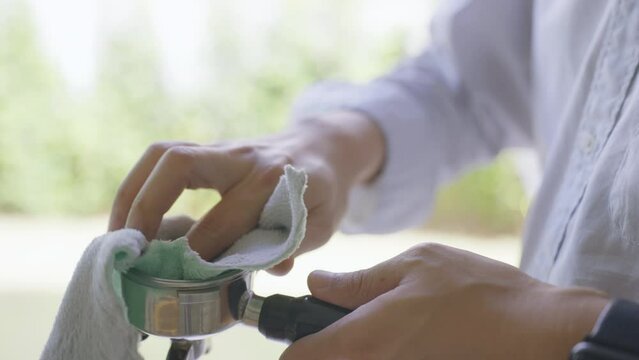 Close Up Slow motion Barista using Fabric Cleaning Potra fillter coffee tools equipment.	