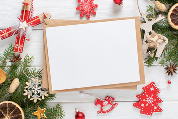 Christmas composition with a kraft envelope and red and white Christmas tree toys at the top on a light pink background. Happy New Year and Merry Christmas.