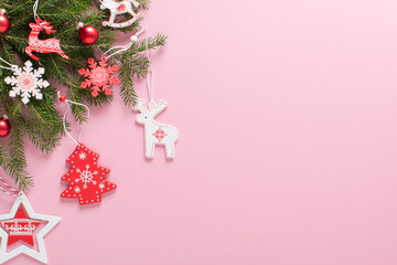 Christmas composition with branches of a Christmas tree and red and white Christmas tree eco-toys on a pink background. Happy New Year and Merry Christmas. Space for copying. Flat position, top view
