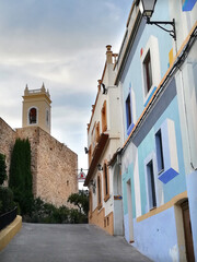 Calpe. Calle típica con casas de colores y torre de la iglesia.