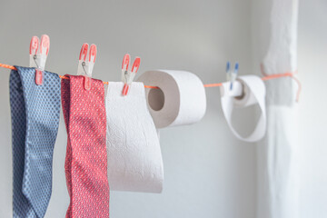 Toilet paper rolls hanging on clothesline for drying and reuse and washing together with expensive...