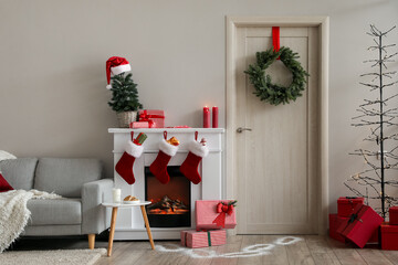 Fototapeta premium Interior of living room with wooden door, fireplace and Christmas decor
