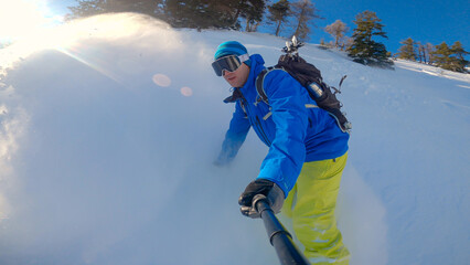 PORTRAIT: Snowboarder enjoying freeriding fresh powder snow in snowy mountains