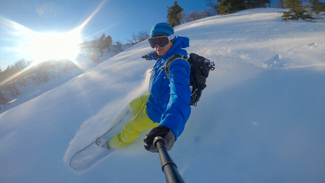 PORTRAIT: Extreme free rider snowboarding and spraying on freshly fallen snow