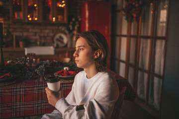 Portrait of candid authentic dreamer boy teenager in sadness depressing emotion at home Xmas