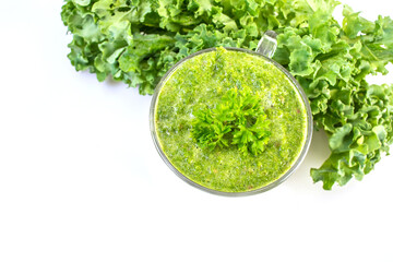 Healthy green kale smoothie in a glass isolated on white table background. Kale is considered a superfood because it's a great source of vitamins and minerals.