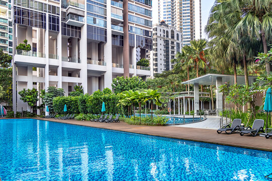 Southeast Asia, Singapore, November, 2022: Modern high-rise residential apartment with a beautiful tropical garden and swimming pool for general use in Singapore. Residential property rental concept.