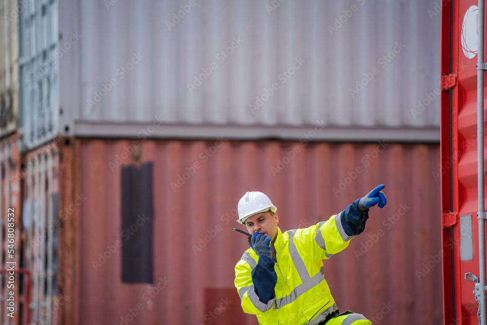 Poster foreman checking about shipping of container box in warehouse stock yard.