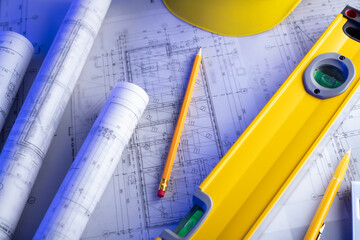 Contractor theme. Plans,  notebook and tool kit of the contractor: yellow hardhat, libella, saw and...
