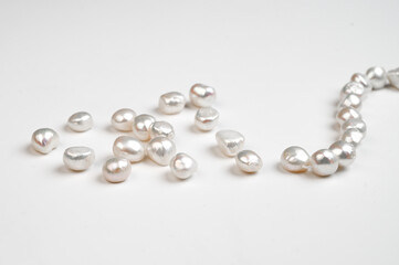 Natural freshwater round baroque pearl beads on white background. Top view