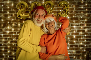 Celebrate event new year for couple of nice people - beautiful senior adult man and woman celebrate holiday by night. Happiness lifestyle for mature retired people, party lights