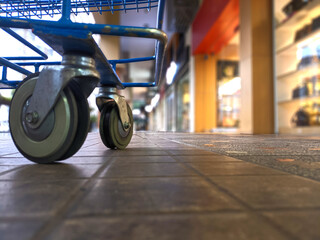 Shopping cart photographed from below in the mall against a blurry background