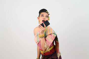 Young beautiful woman dress up in Thai northern region pose with smartphone