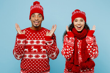Merry young surprised shocked couple friends two man woman wear red Christmas sweater Santa hat...