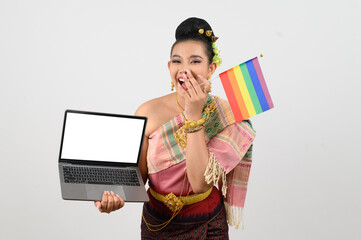Young beautiful woman dress up in hai northeastern region holding rainbow flag and laptop computer