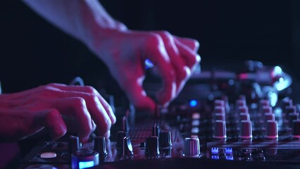 Club dj mixing music with sound mixer on stage. Disc jockey plays set on party in night club