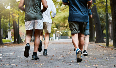 Fitness, men and running club in park, cropped legs in nature for exercise on garden path together....