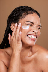 Beauty, face cream and woman in studio, happy and relax with skincare, pamper and cleaning on brown...