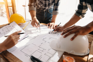 wo colleagues discussing data working and tablet, laptop with on on architectural project at construction site at desk