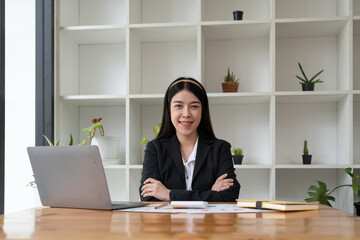 Portrait confidence asian business woman looking on camera sitting at work desk in office.