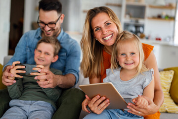 Happy family spending time at home with digital devices together. Technology people fun concept.