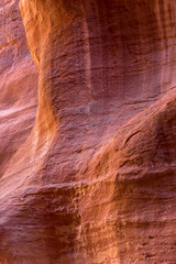 The Siq, narrow red canyon wall texture background in Petra, Jordan, UNESCO World Heritage Site