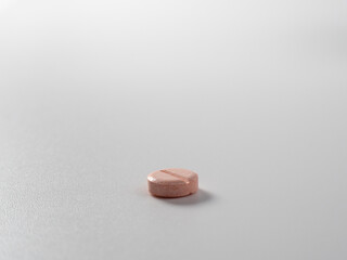 Pink pill on a light background. medication on a white background.