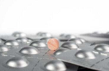 Pink pill on the background of packed pills. medicine in tablets.