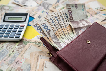 financial concept uah ukraine money with calculator and purse on desk