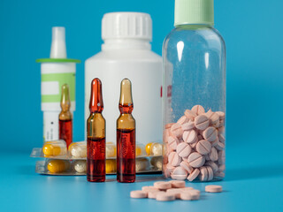 Various medicines on a blue background. Pills, spray, capsules and ampoules on a blue background.