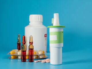 Various medicines on a blue background. Pills, spray, capsules and ampoules on a blue background.