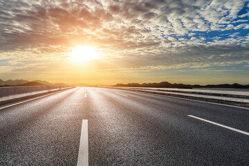 Asphalt road and sea with mountain nature landscape at sunrise