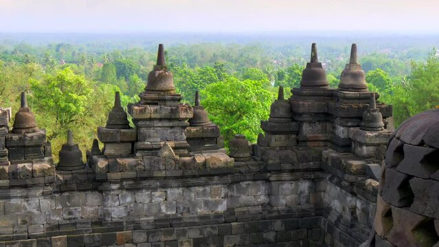 Gimbal morning shot of Borobudur temple, Java, Indonesia. Mahayana Buddhist world's largest temple in Magelang. Buddhism architecture. Green jungle at background. UHD, 4K