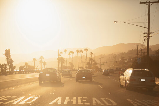 Cars driving on road at sunset