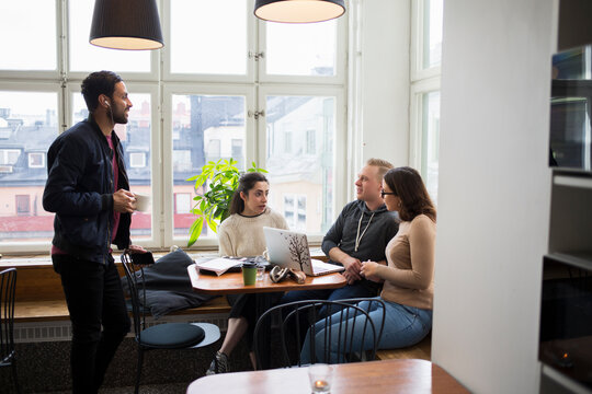 Coworkers talking in office break room