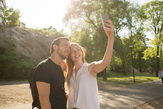 Couple taking selfie under sunshine in park