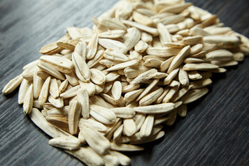 White sunflower seeds on table. Heap of Salted roasted sunflower seeds with white shell on wooden background