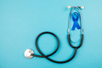 Top view photo of stethoscope and blue ribbon symbol of prostate cancer awareness on isolated...