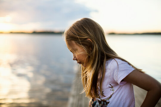 Girl by lake during sunset