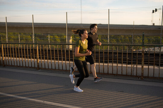Couple jogging together on bridge