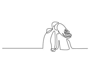 young couple in love sitting outside kissing