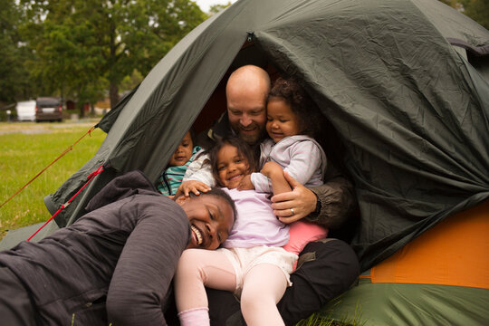 Family hugging in tent while camping