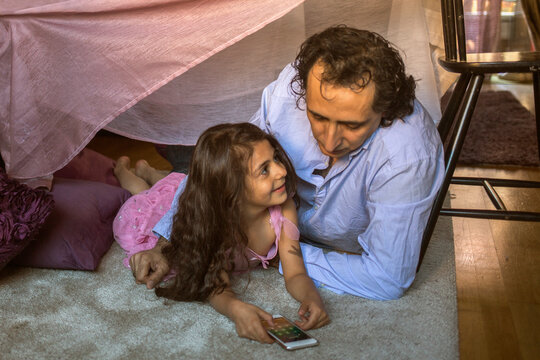 Man with his daughter in blanket fort