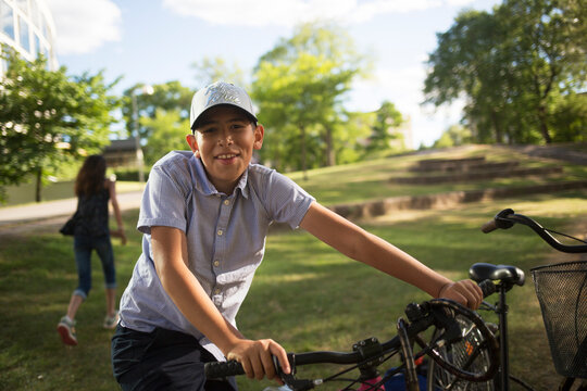 Smiling boy with bicycle in park