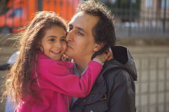Man kissing his smiling daughter
